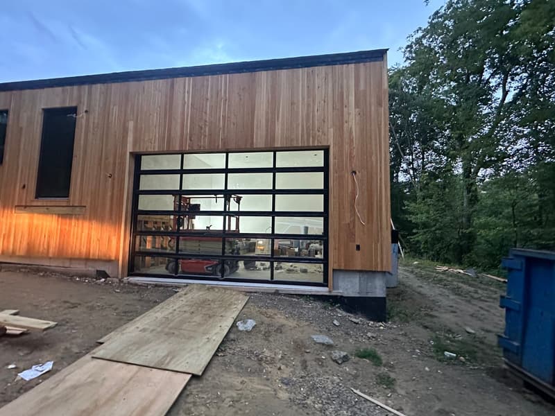 Modern full-view glass garage door on a cedar Massachusetts building